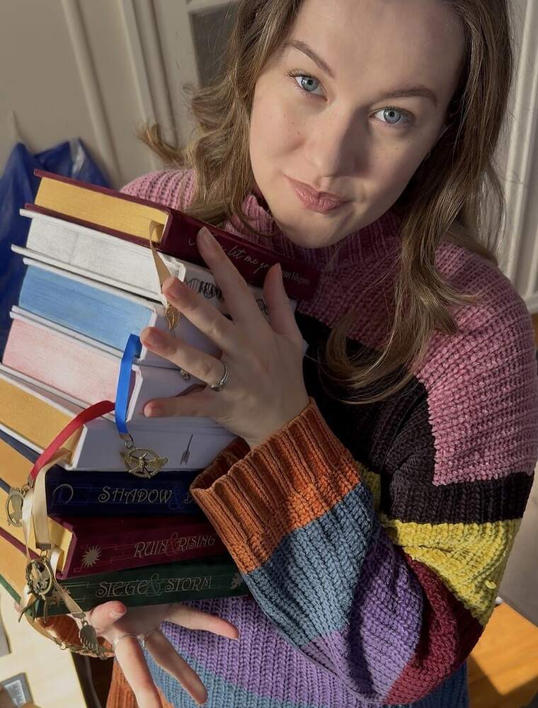 Lauren holding a stack of rebound books